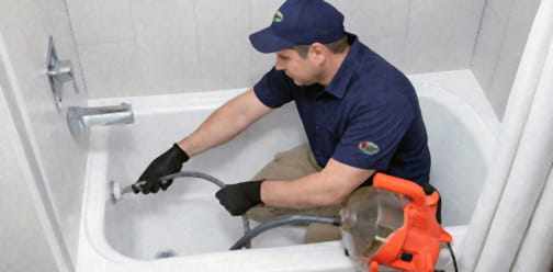 Plumber unclogging bathtub drain Brentwood CA