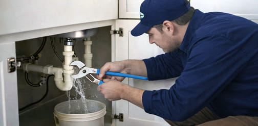 Emergency plumber checking leaking pipes under kitchen sink Brentwood CA